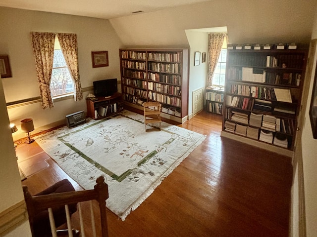 living area featuring a wealth of natural light, hardwood / wood-style floors, and lofted ceiling