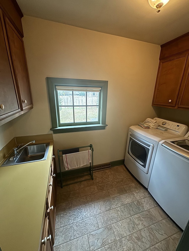 laundry area with cabinets, sink, and washing machine and dryer