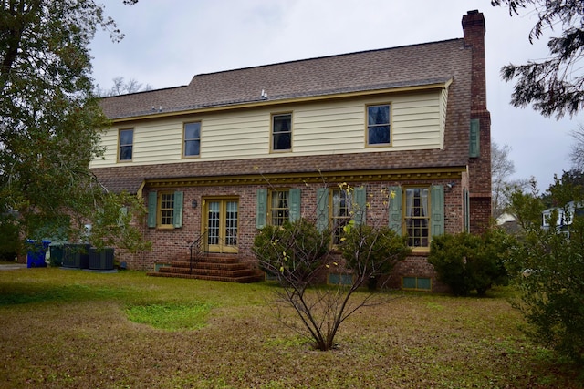 rear view of house with a lawn and central AC