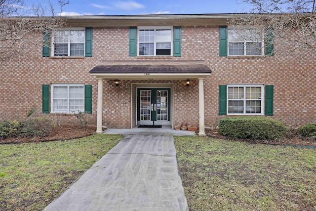 view of front of property featuring french doors and a front lawn