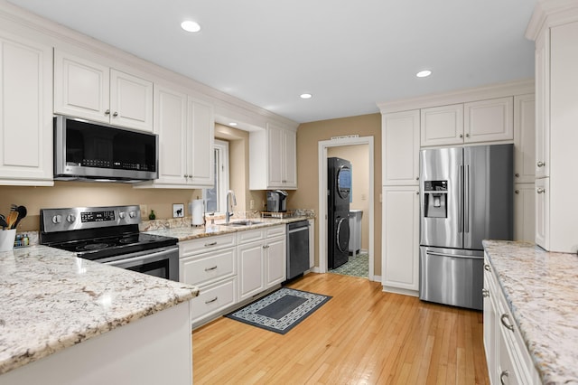 kitchen featuring sink, light wood-type flooring, white cabinets, and appliances with stainless steel finishes