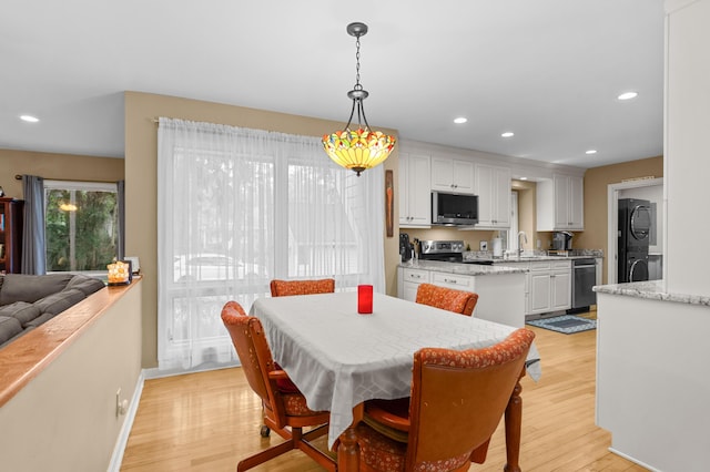 dining area with sink and light wood-type flooring