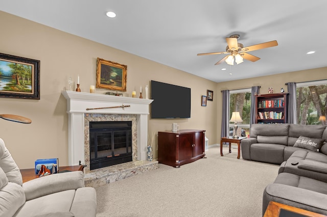 carpeted living room with ceiling fan and a premium fireplace