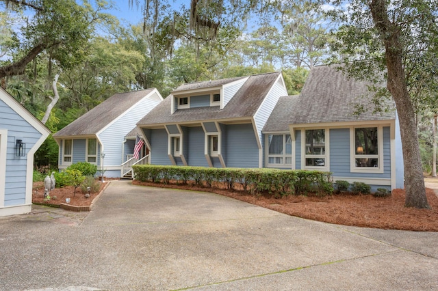 view of front of house featuring driveway and a shingled roof