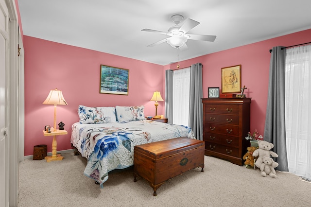 bedroom with ceiling fan and light carpet