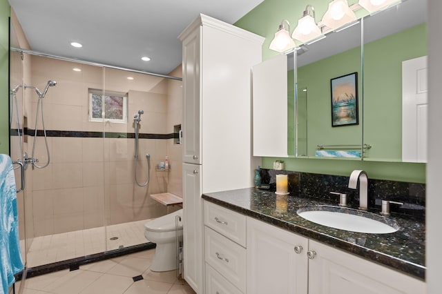 bathroom with toilet, vanity, tile patterned floors, and walk in shower