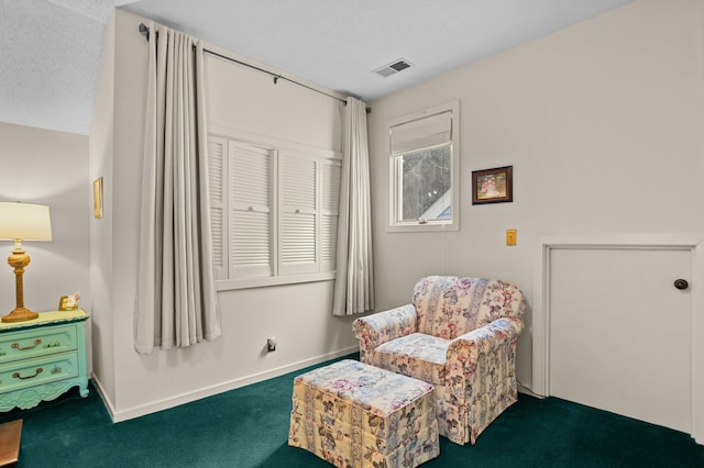 living area with dark carpet and a textured ceiling