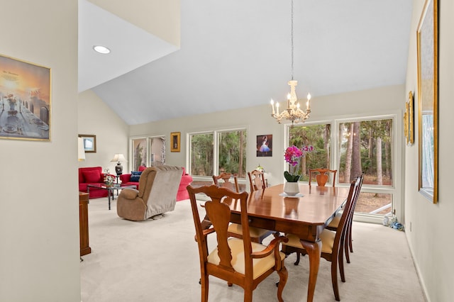 dining space with high vaulted ceiling, light carpet, and a chandelier