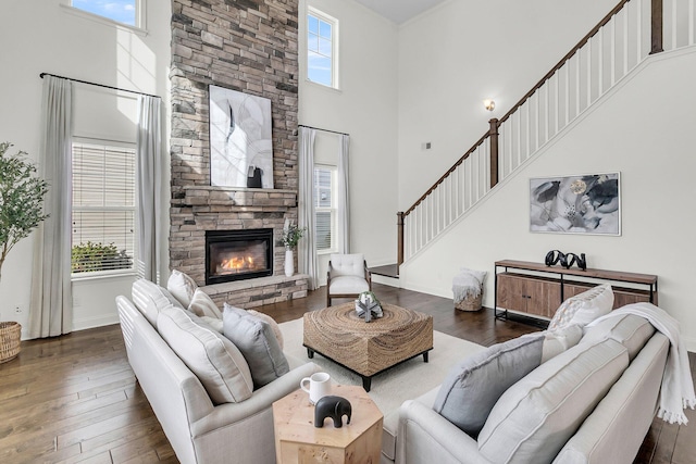 living room with a fireplace, dark wood-type flooring, and a high ceiling