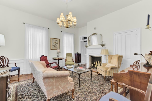 living room featuring wood finished floors, a notable chandelier, and a fireplace