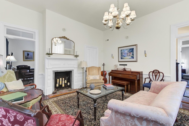 living area featuring a fireplace, an inviting chandelier, and wood finished floors