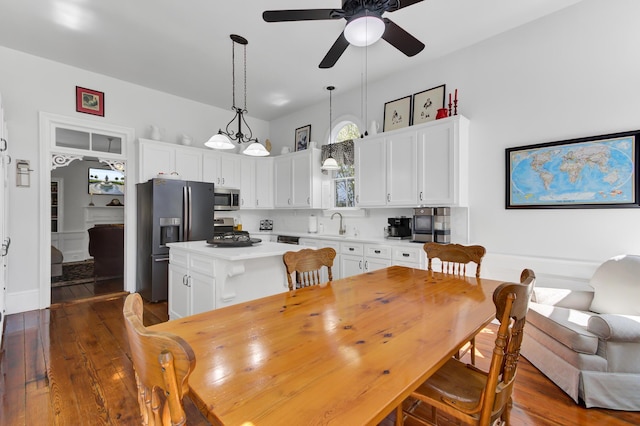 dining space featuring a ceiling fan and dark wood-style floors