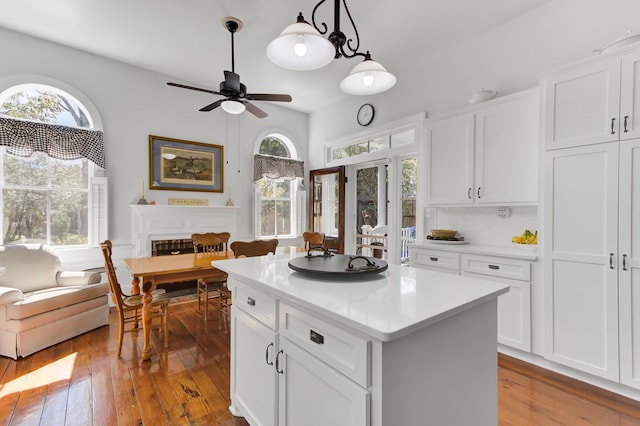 kitchen featuring white cabinetry, plenty of natural light, a center island, and hardwood / wood-style flooring