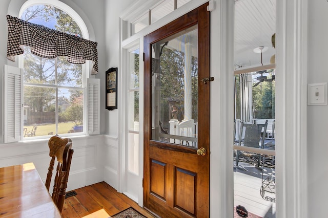 entrance foyer with dark wood-style floors, plenty of natural light, and a decorative wall