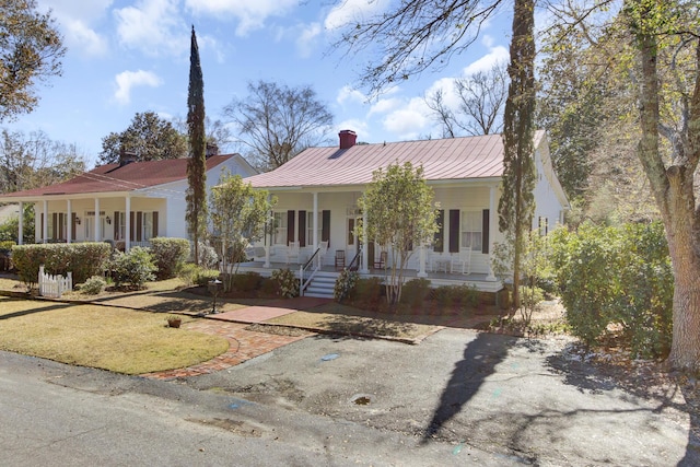 view of front facade with covered porch and metal roof