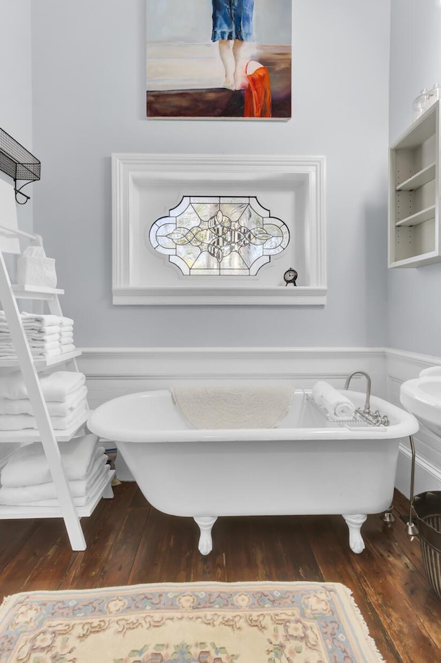 full bathroom with a soaking tub, wood finished floors, and wainscoting