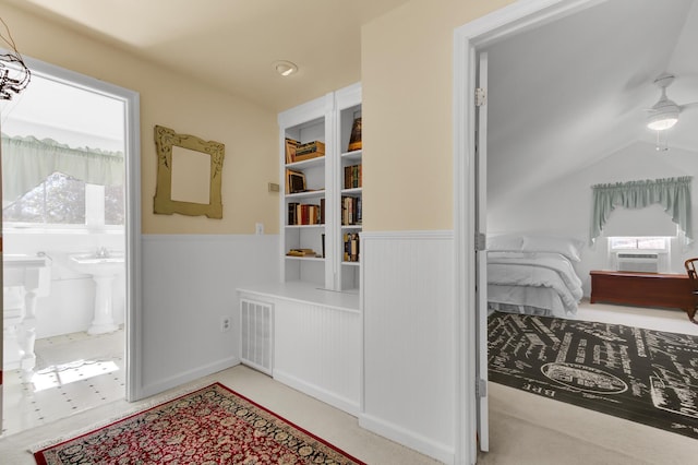 corridor featuring cooling unit, visible vents, a wainscoted wall, and a sink