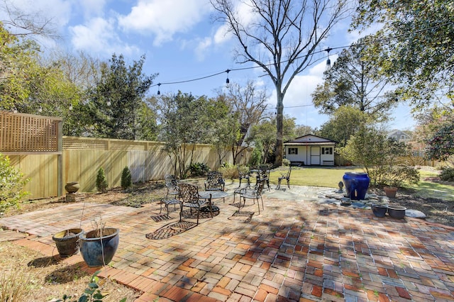 view of patio with an outbuilding and a fenced backyard