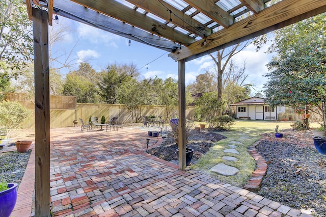 view of patio / terrace with an outbuilding, a fenced backyard, and a pergola