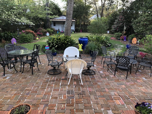 view of patio / terrace featuring outdoor dining space, an outbuilding, and fence