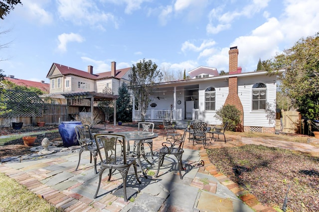 rear view of property with a patio area, fence, a pergola, and a chimney