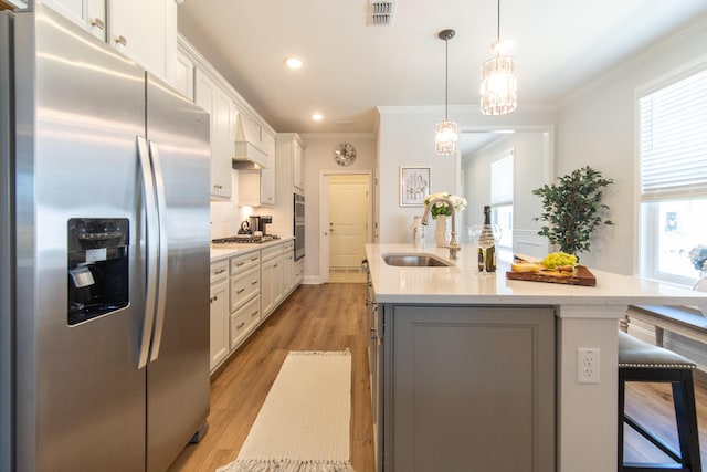 754 Blue Iris Way, Summerville, SC 29486 - kitchen with stainless steel appliances, a kitchen island with sink, ornamental molding, white cabinetry, and a kitchen breakfast bar