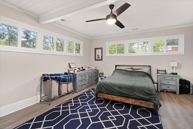 bedroom featuring hardwood / wood-style flooring, ceiling fan, crown molding, and beam ceiling