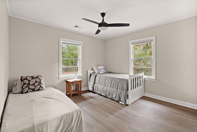 bedroom featuring crown molding, ceiling fan, and light wood-type flooring