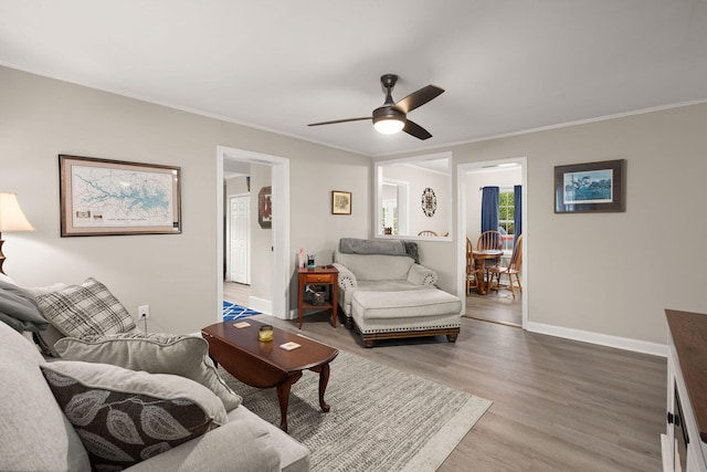 living room featuring crown molding, hardwood / wood-style flooring, and ceiling fan