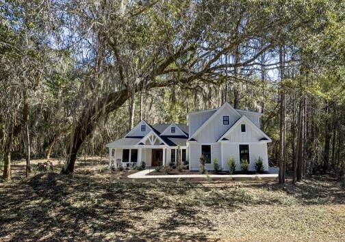 modern farmhouse featuring a wooded view