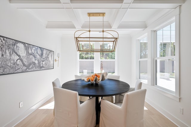 dining area featuring light wood finished floors, plenty of natural light, and coffered ceiling