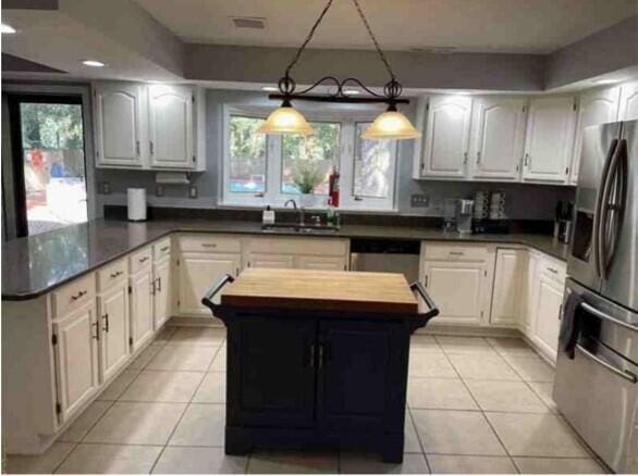 104 Legend Oaks Way, Summerville, SC 29485 - kitchen featuring light tile patterned floors, appliances with stainless steel finishes, a sink, butcher block countertops, and a peninsula