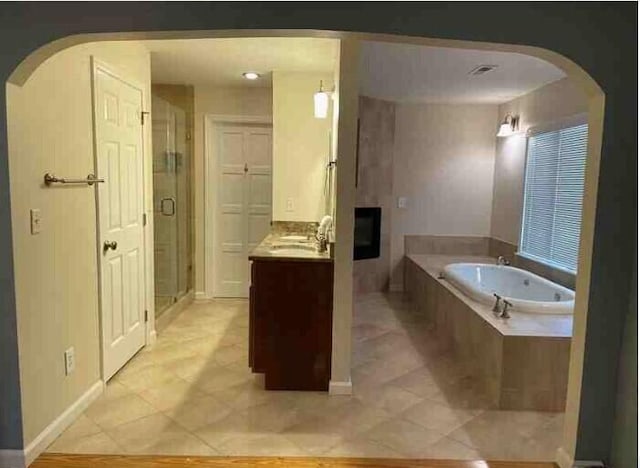 104 Legend Oaks Way, Summerville, SC 29485 - full bathroom with a garden tub, a fireplace, vanity, a shower stall, and tile patterned floors