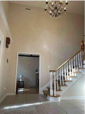 104 Legend Oaks Way, Summerville, SC 29485 - tiled foyer entrance featuring visible vents, baseboards, a towering ceiling, stairs, and a notable chandelier