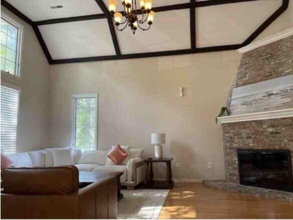 104 Legend Oaks Way, Summerville, SC 29485 - living area with a high ceiling, a fireplace, wood finished floors, and a notable chandelier
