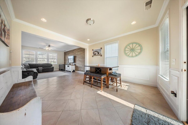 dining area with light tile patterned floors, a wainscoted wall, recessed lighting, and ornamental molding