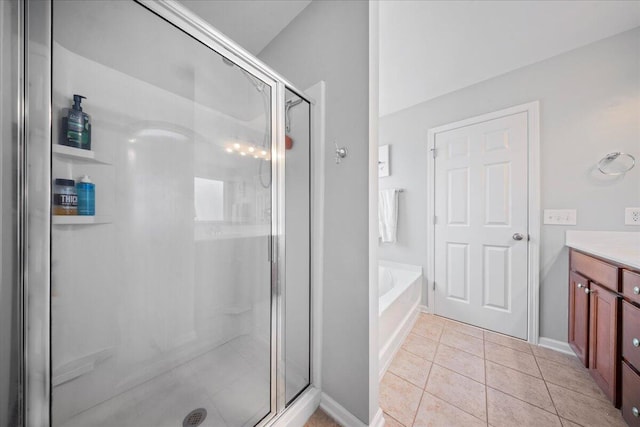 bathroom featuring tile patterned flooring, a shower stall, baseboards, a garden tub, and vanity