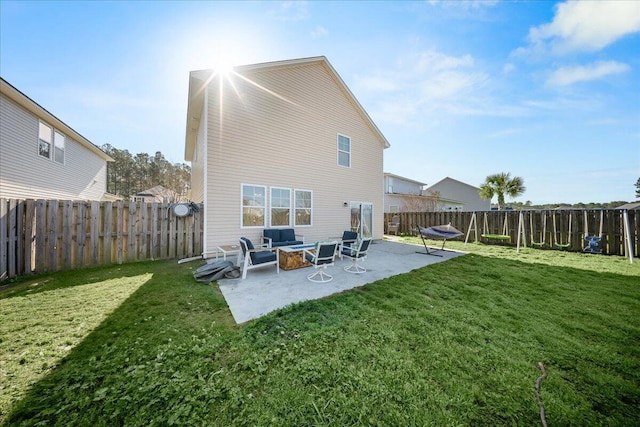 rear view of house with a yard, a patio area, a fenced backyard, and a fire pit