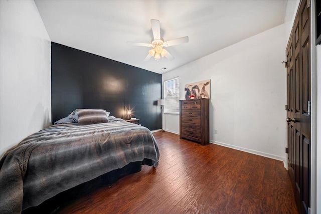 bedroom with ceiling fan, baseboards, and wood finished floors