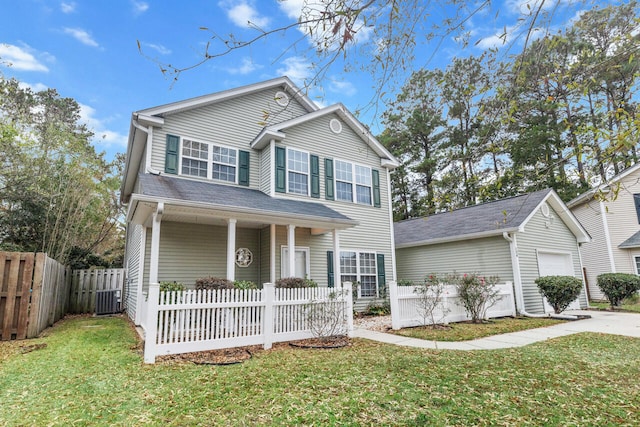 view of front of house with an outbuilding, a garage, a front lawn, central AC, and covered porch