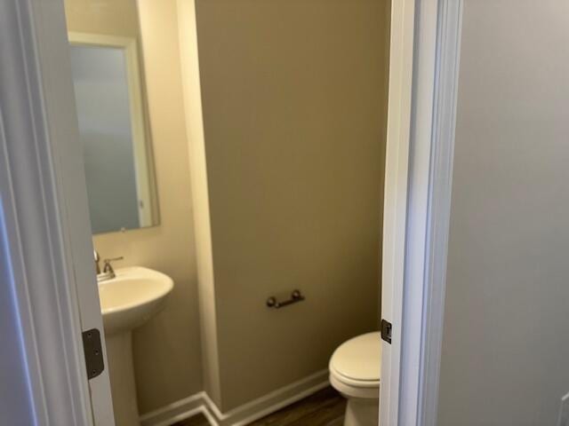 bathroom with hardwood / wood-style floors and toilet