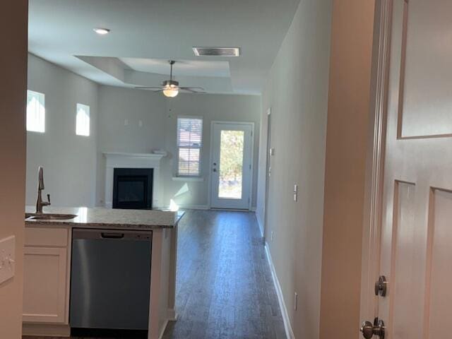 kitchen featuring dishwasher, a raised ceiling, sink, dark hardwood / wood-style floors, and white cabinetry