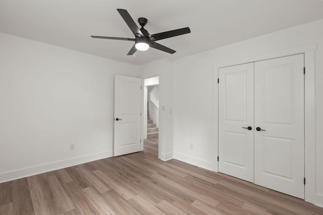 unfurnished bedroom with light wood-type flooring, a closet, and ceiling fan