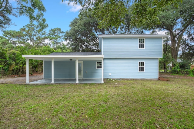 back of house featuring a lawn and a patio