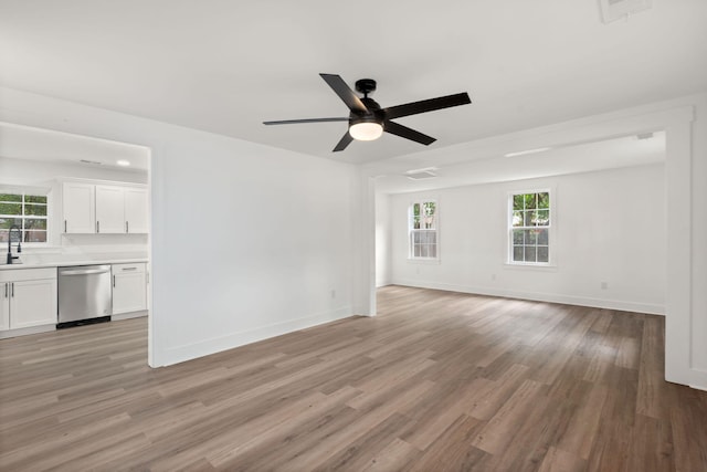 unfurnished living room with light hardwood / wood-style floors, ceiling fan, and sink