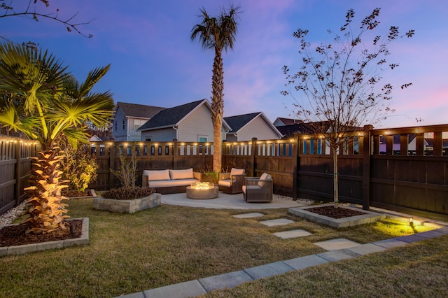 yard at dusk featuring a patio and an outdoor living space with a fire pit