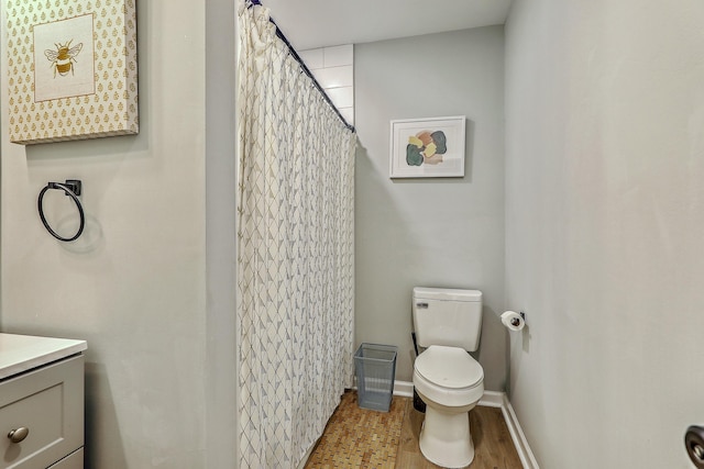 full bath featuring toilet, wood finished floors, a shower with shower curtain, baseboards, and vanity