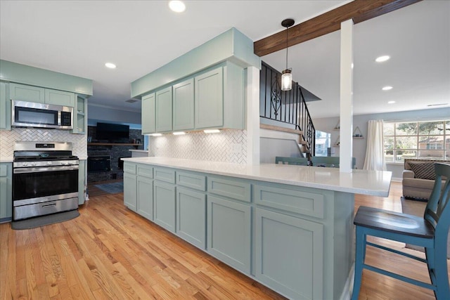 1115 O T Wallace Blvd, Moncks Corner, SC 29461 - kitchen with appliances with stainless steel finishes, backsplash, light countertops, light wood-type flooring, and recessed lighting