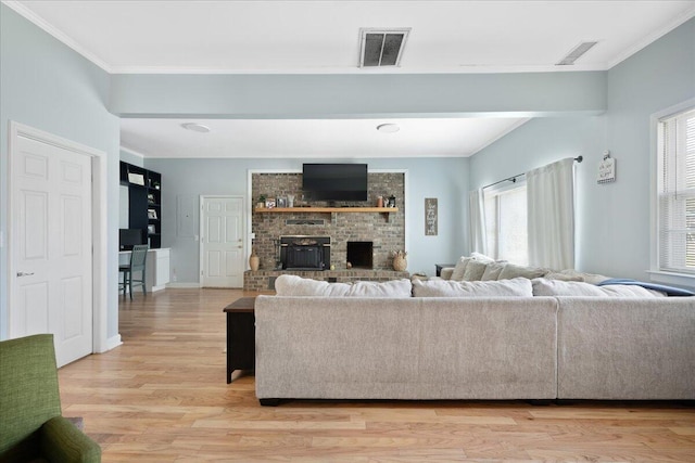 1115 O T Wallace Blvd, Moncks Corner, SC 29461 - living area featuring healthy amount of natural light, crown molding, light wood-style flooring, a fireplace, and baseboards