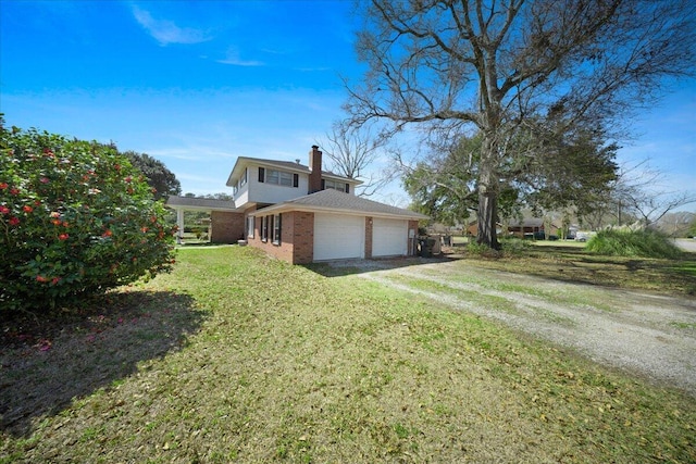 1115 O T Wallace Blvd, Moncks Corner, SC 29461 - view of property exterior with brick siding, driveway, a garage, a yard, and a chimney